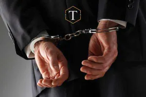 a man wearing a suit in handcuffs